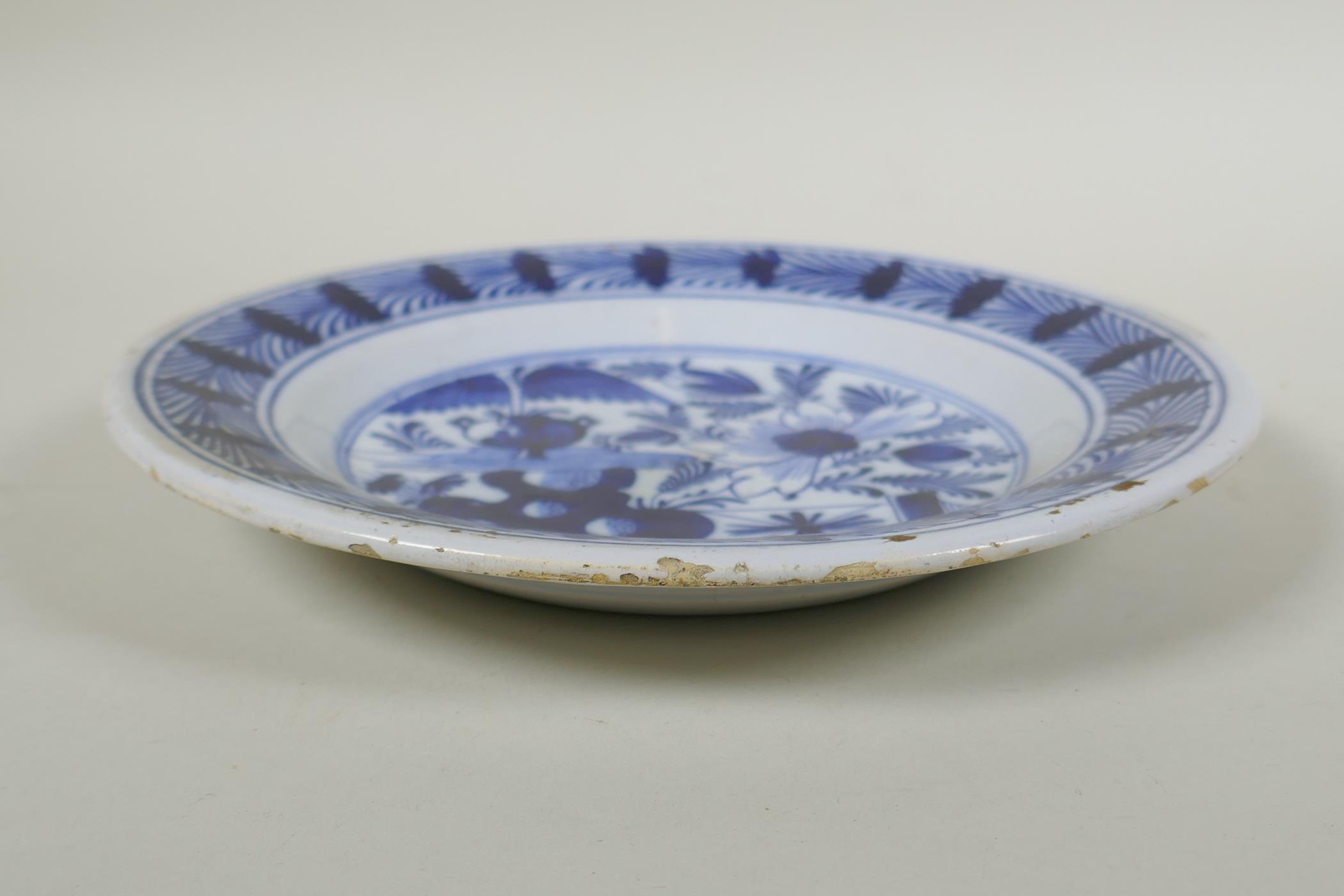 An C18th Dutch Delft blue plate with floral decoration, 23cm diameter - Image 3 of 4