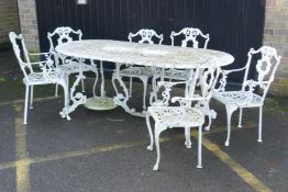 A painted metal garden table and six chairs ensuite
