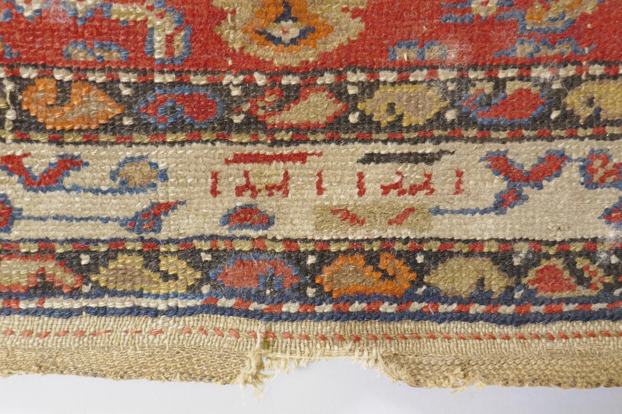 An antique Persian hand woven wool carpet, with medallion design on a red and blue field with - Image 3 of 5