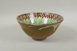 An Islamic earthenware bowl with sponged decoration, 21cm diameter
