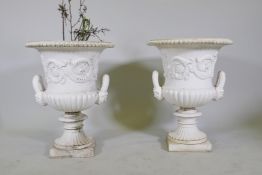 A pair of painted cast iron campagna garden urns, 60cm high