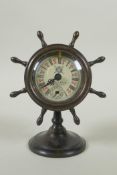 A bronze desk clock in the form of a ship's wheel, the dial with Roman numerals and smaller