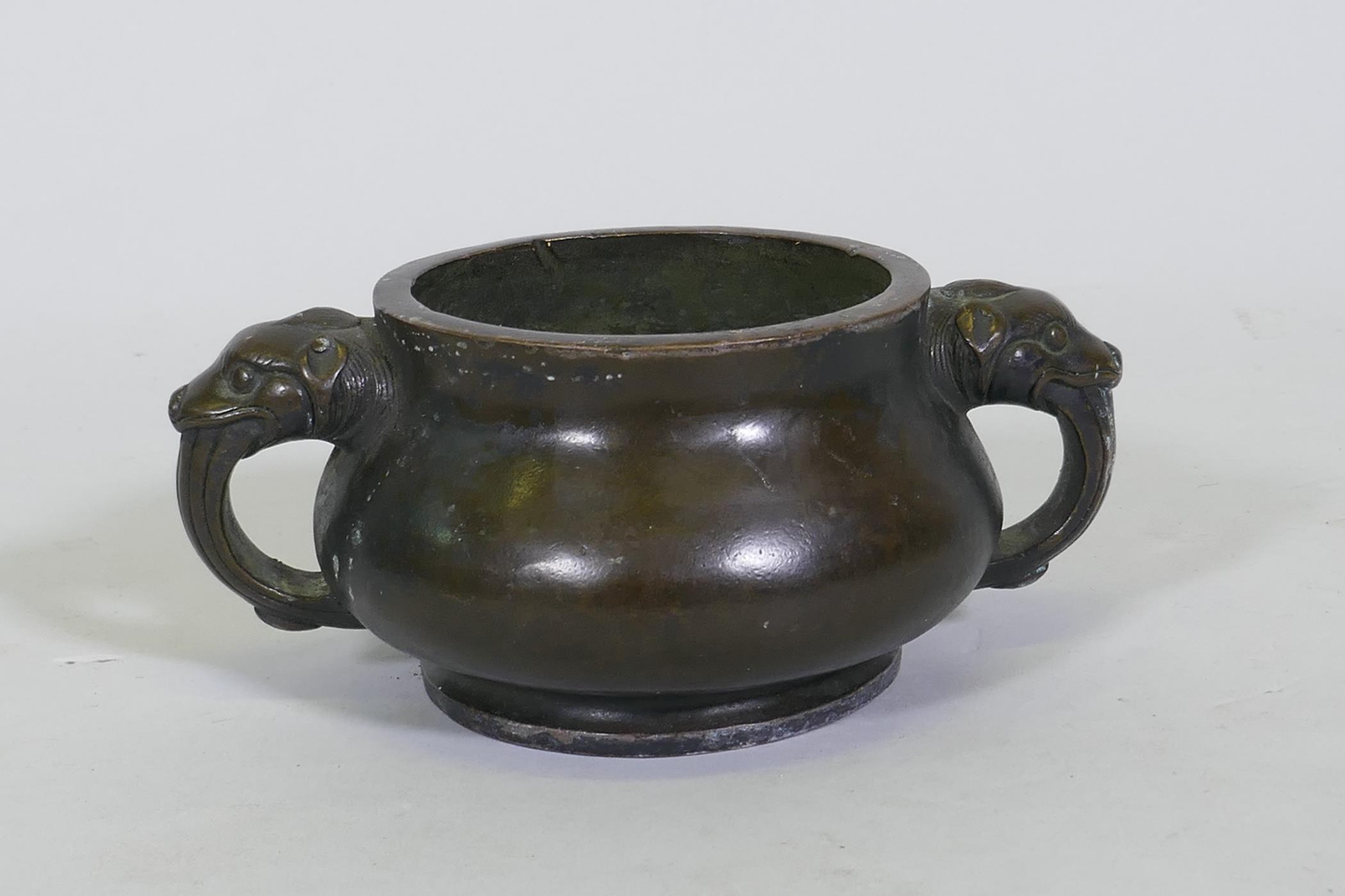 A Chinese bronze censer with dragon mask handles, seal mark to base, 19cm diameter