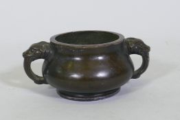 A Chinese bronze censer with dragon mask handles, seal mark to base, 19cm diameter