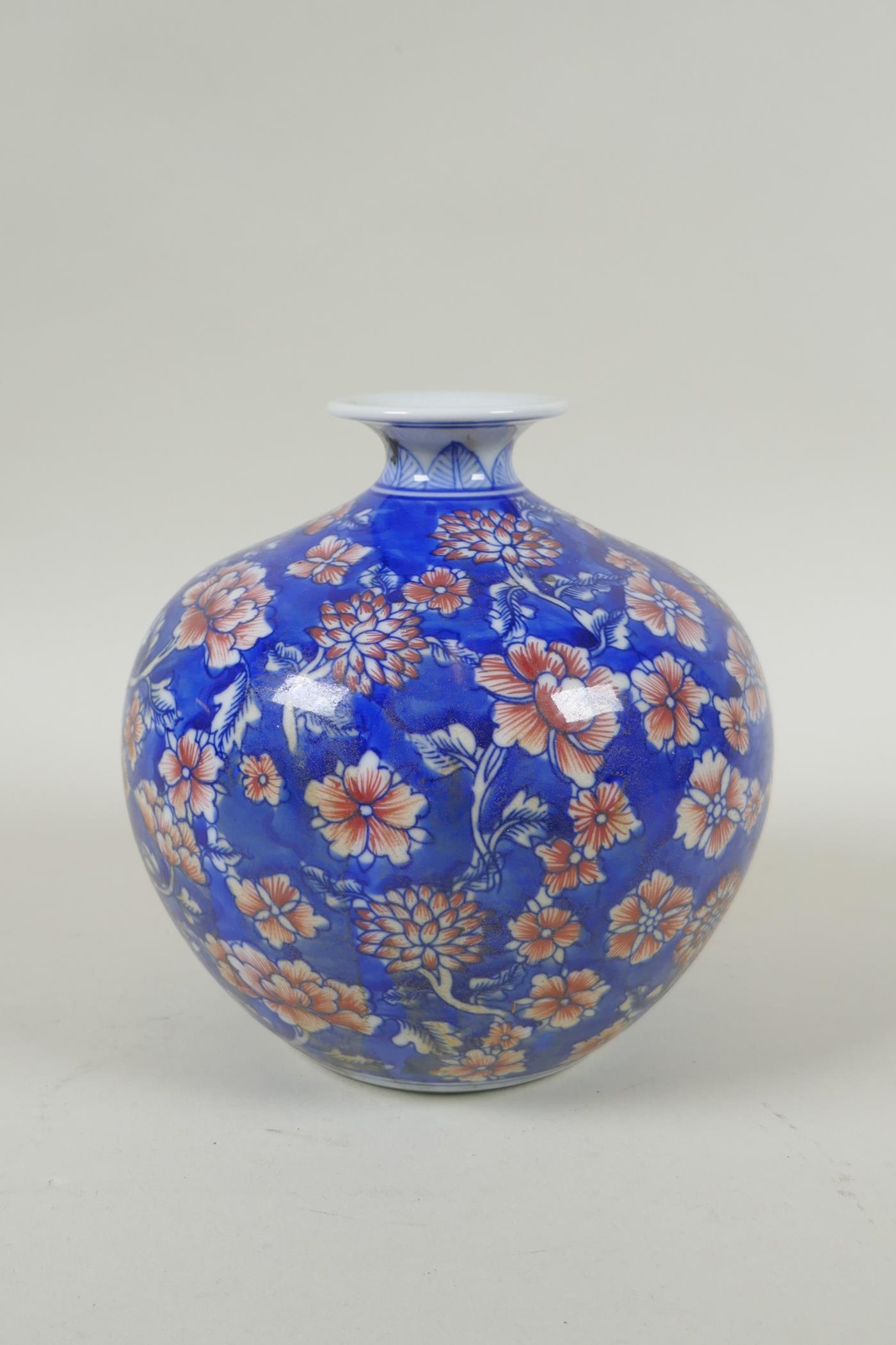 A Chinese blue and white porcelain pomegranate shaped vase, with allover floral decoration and red