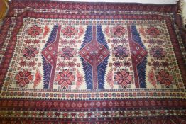 A Caucasian Kazak wool carpet with geometric designs on a red field, 200 x 300cm