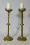 A pair of brass pricket candlesticks, 68cm high