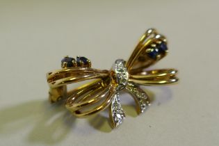 A 9ct gold bow shaped brooch inset with diamonds, 2.5cm wide, 3.6g