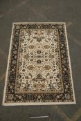 A Belgian cream ground rug with Oriental allover floral design and black borders, 150 x 212cm