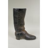 A painted cast iron door stop in the form of a riding boot, 36cm high