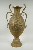 An Indian bronze urn with two handles in the form of cobras, with allover repousse decoration
