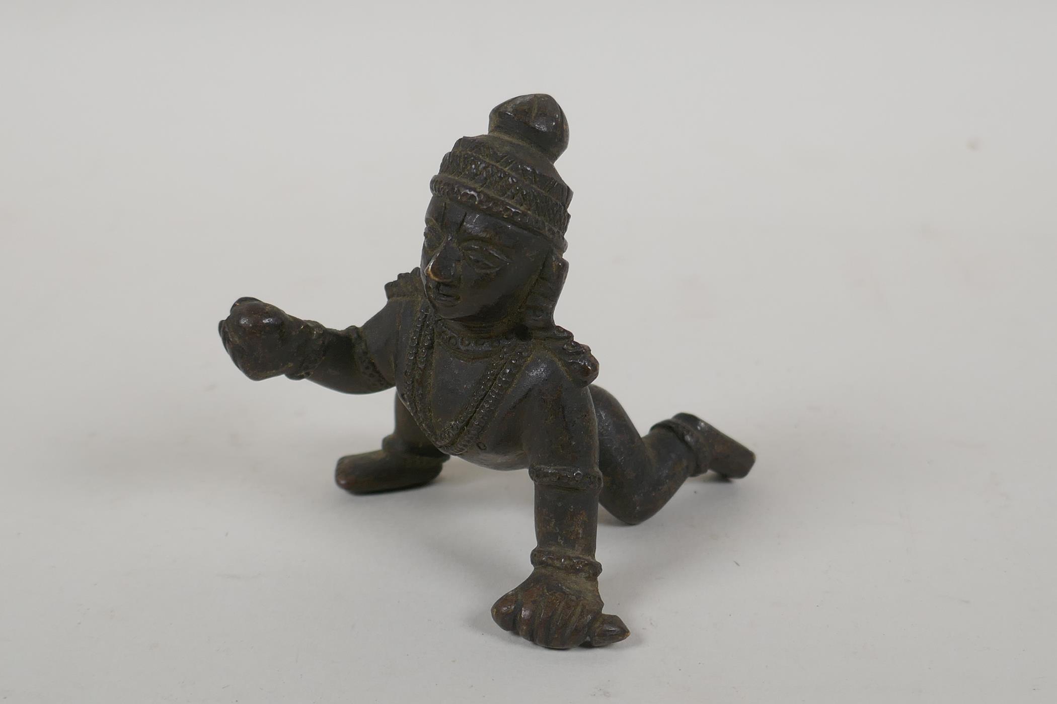 An antique Indian bronze of a crawling figure, 8cm long