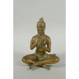 A Cambodian bronze figure of a seated musician playing a flute, 15cm high