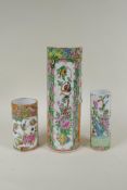A C19th Chinese Canton famille rose cylinder vase and two smaller, all with decorative panels