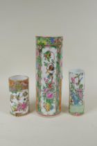 A C19th Chinese Canton famille rose cylinder vase and two smaller, all with decorative panels