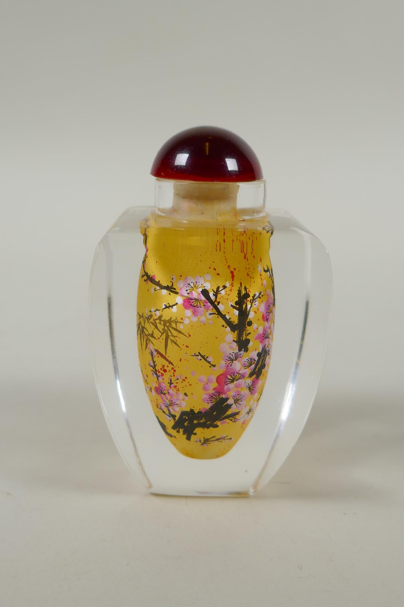 A Chinese reverse painted glass snuff bottle decorated with a branch in bloom, 9cm high