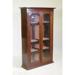 A Victorian mahogany bookcase with two arched glazed doors, raised on a shaped plinth, 86 x 30 x