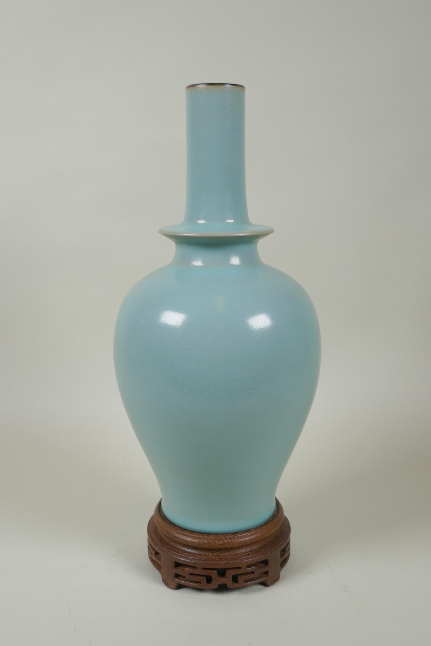 A Chinese Ru ware style porcelain vase, on a carved wood stand, 33cm high