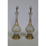 A pair of cut and etched glass table lamps with gilt and enamel decoration, a brass bases, 67cm high