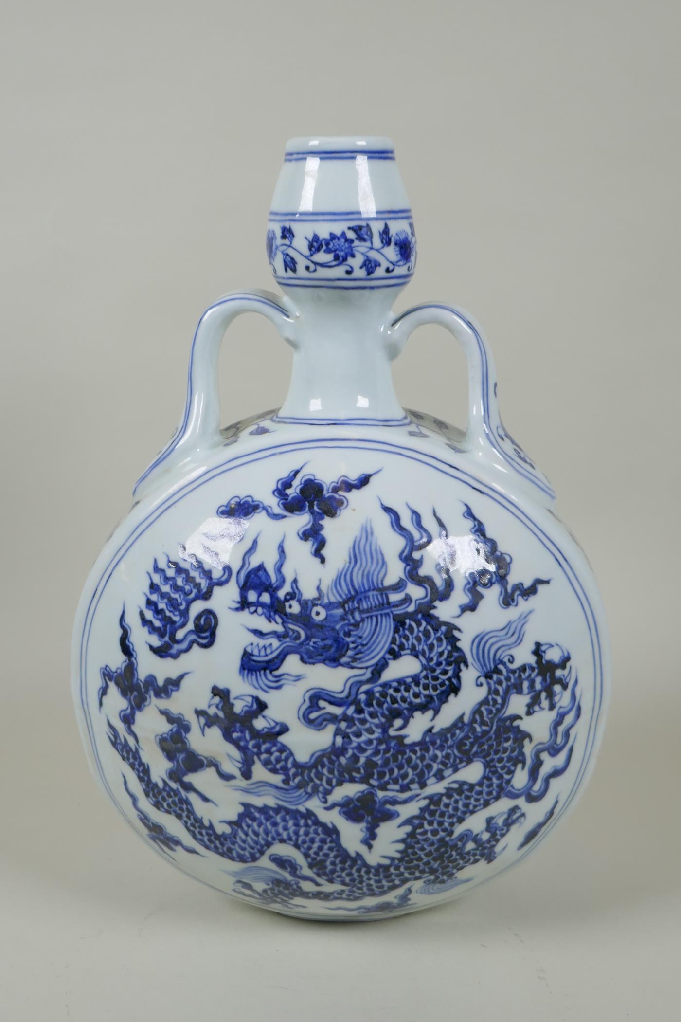 A Chinese blue and white porcelain two handled moon flask decorated with a dragon and flaming pearl,