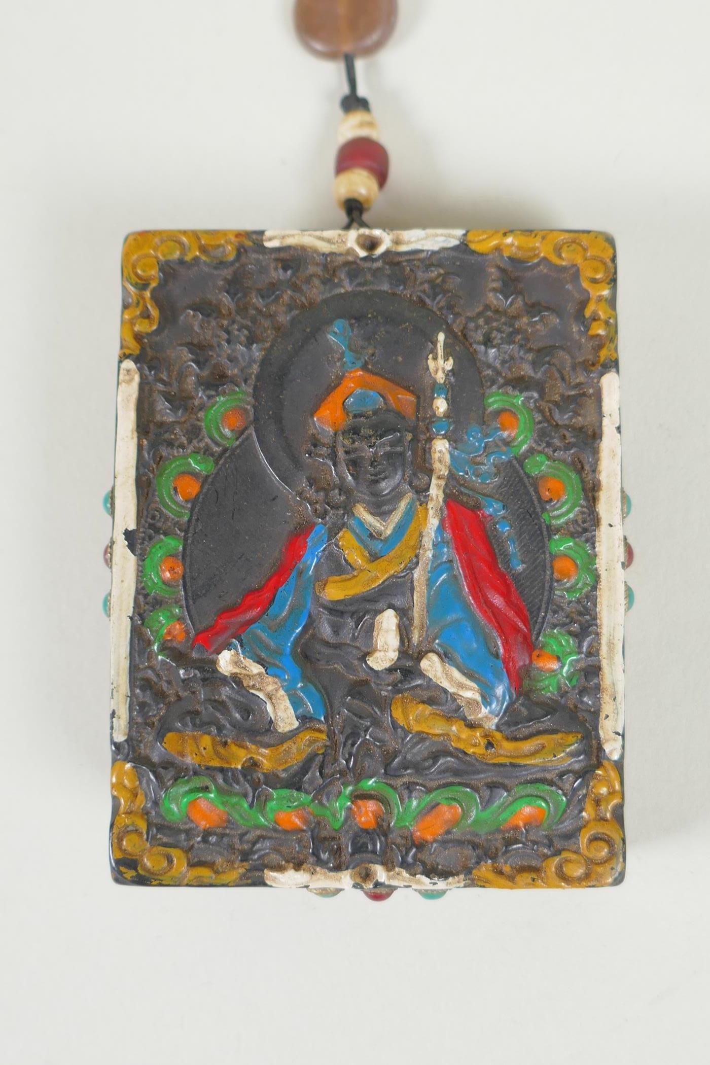 A Tibetan carved and painted hardstone tablet depicting a deity, the reverse set with abalone, dzi - Image 2 of 4