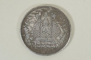 A Tibetan white metal token decorated with a tanka depiction and character inscription verso, 4cm
