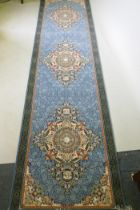 An Iranian fine woven blue ground runner with a medallion design and darker blue border, 80 x 310cm