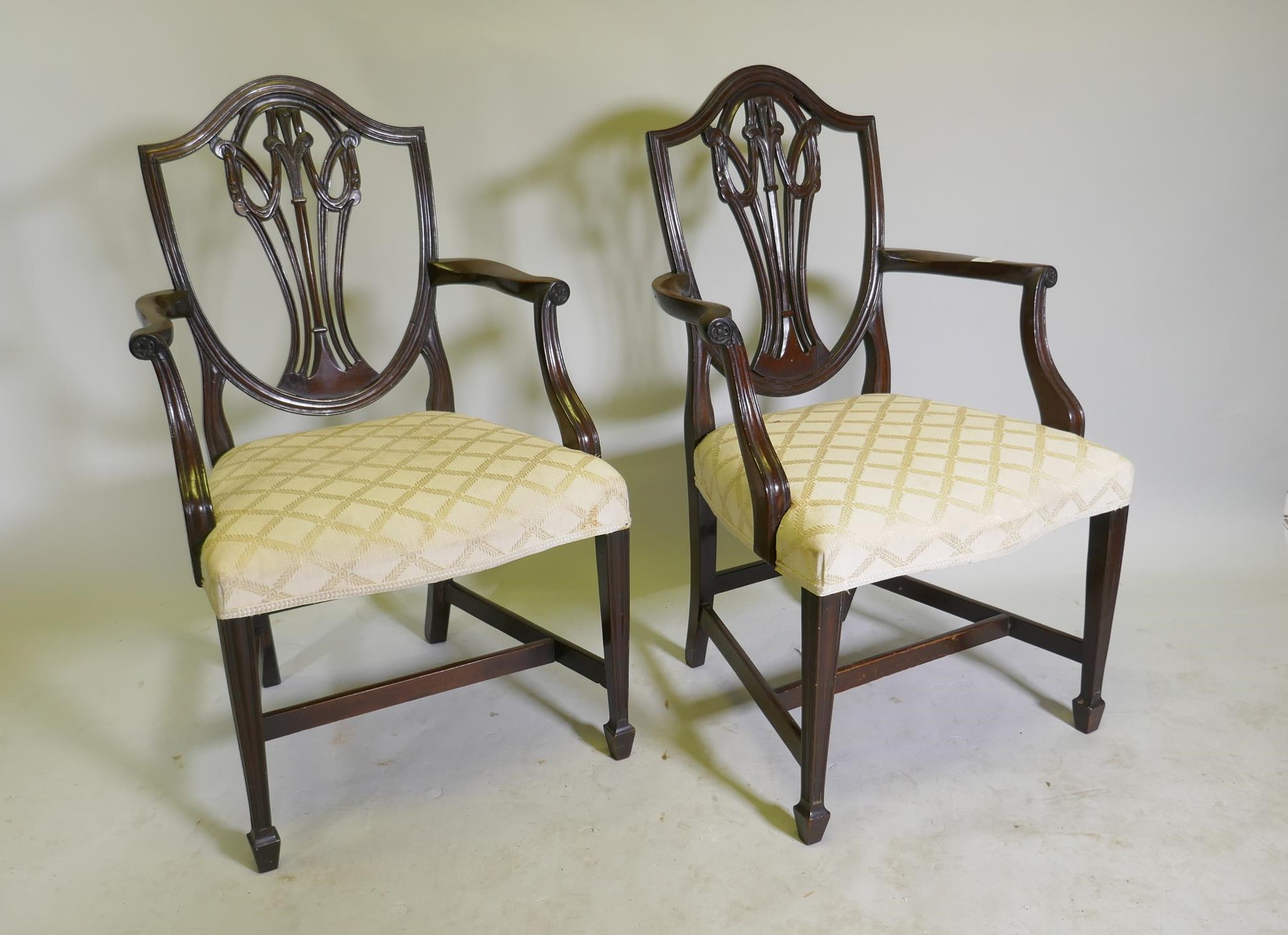 A pair of Hepplewhite style shield back mahogany elbow chairs, late C19th/early C20th
