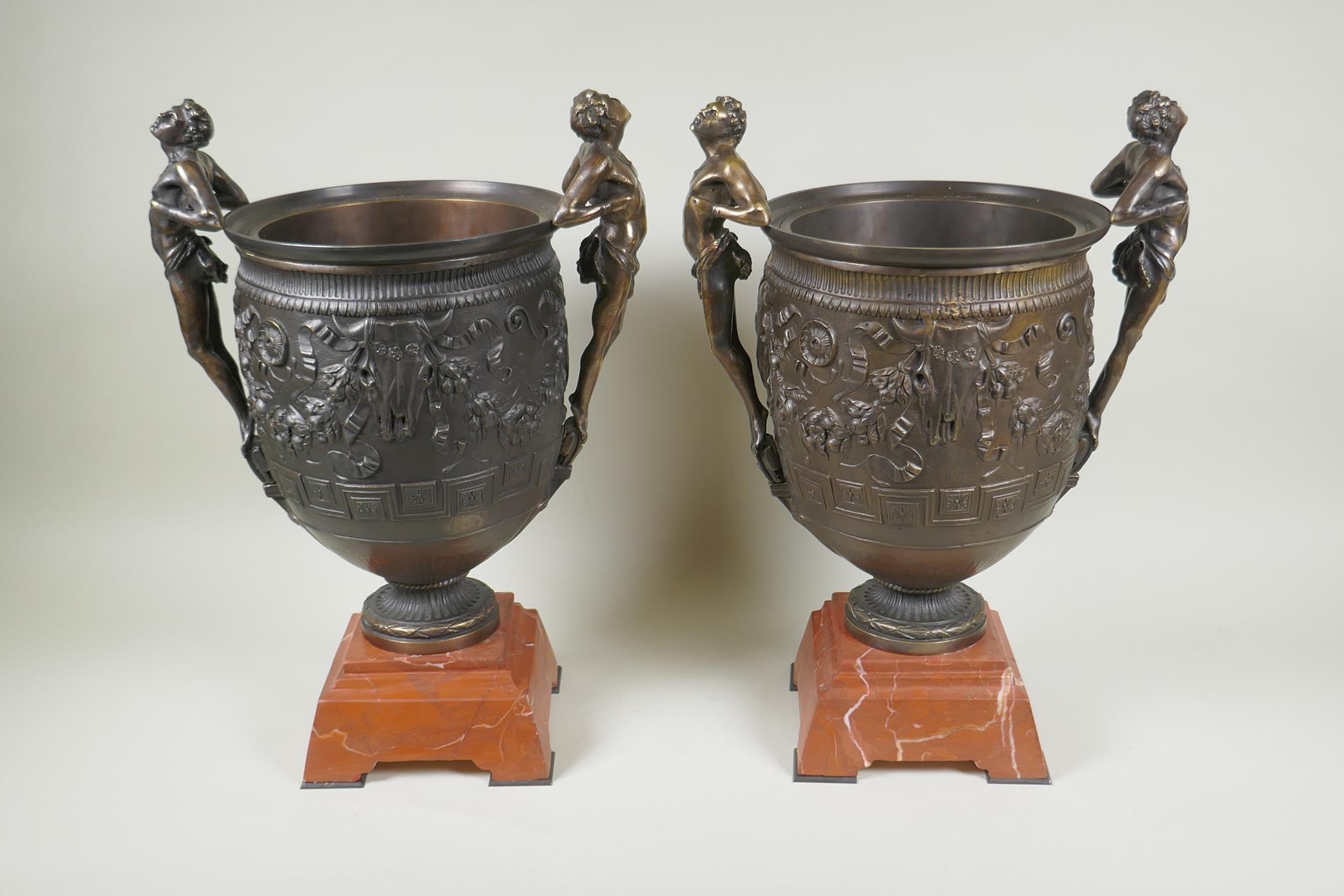 A pair of Grand Tour style bronze urns on red marbled bases, with male figural twin handles, 41cm - Image 5 of 6