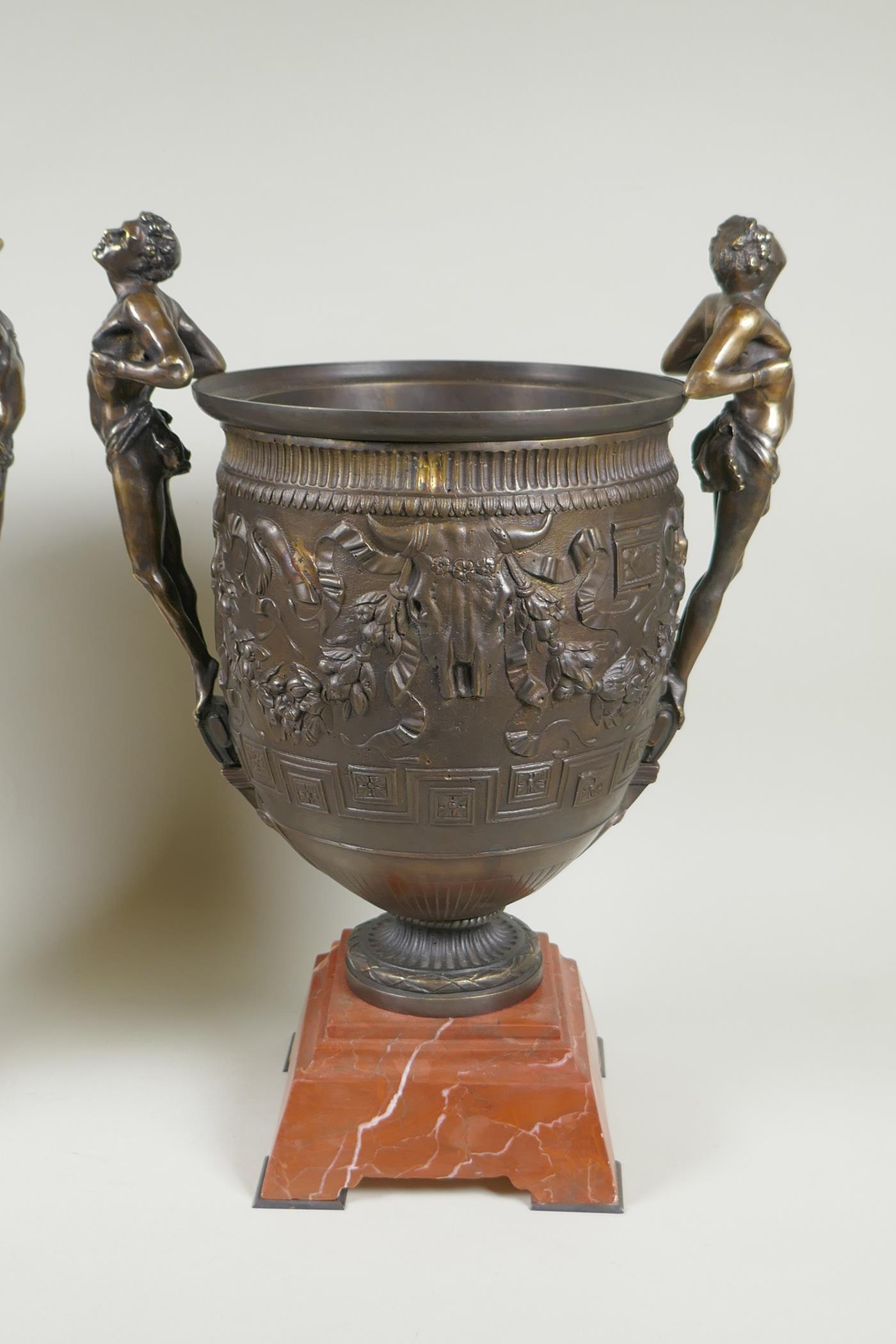 A pair of Grand Tour style bronze urns on red marbled bases, with male figural twin handles, 41cm - Image 2 of 6