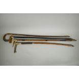 Four antique walking sticks with silver mounts and cuffs, two with carved antler handles, largest