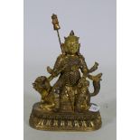 A Chinese gilt bronze figure of a deity seated on a dragon, 26cm high