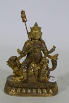 A Chinese gilt bronze figure of a deity seated on a dragon, 26cm high