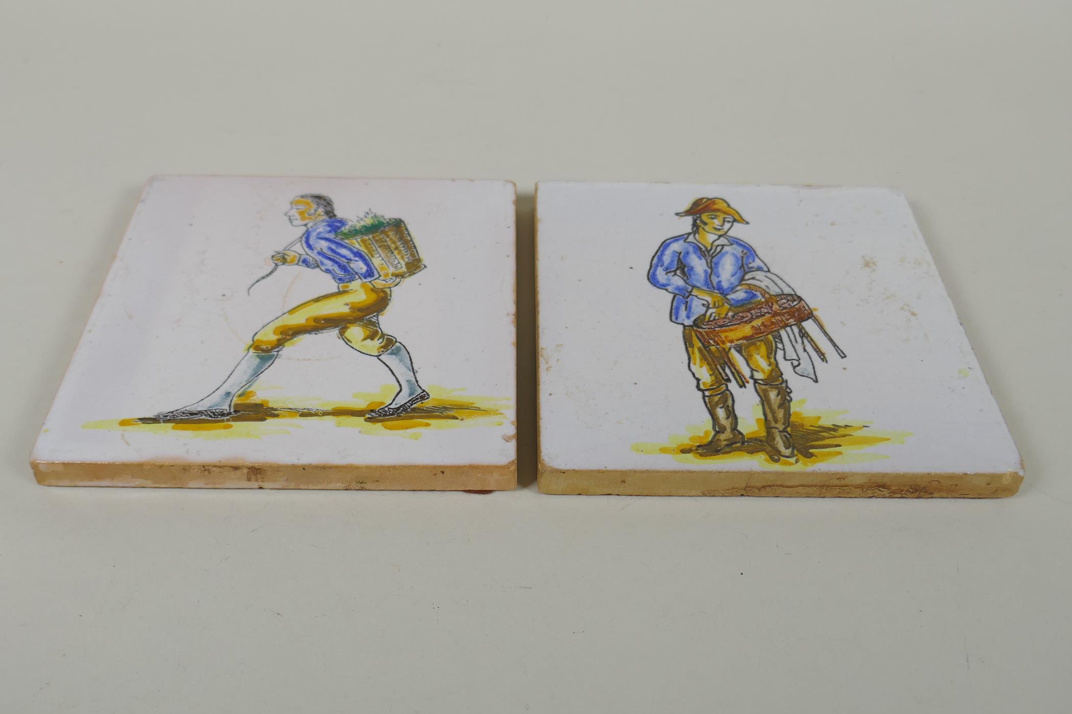 A pair of antique faience tiles decorated with trades people, 14 x 14cm - Image 2 of 2