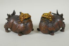 A pair of Chinese filled bronze kylin with gilt heads, 11cm long
