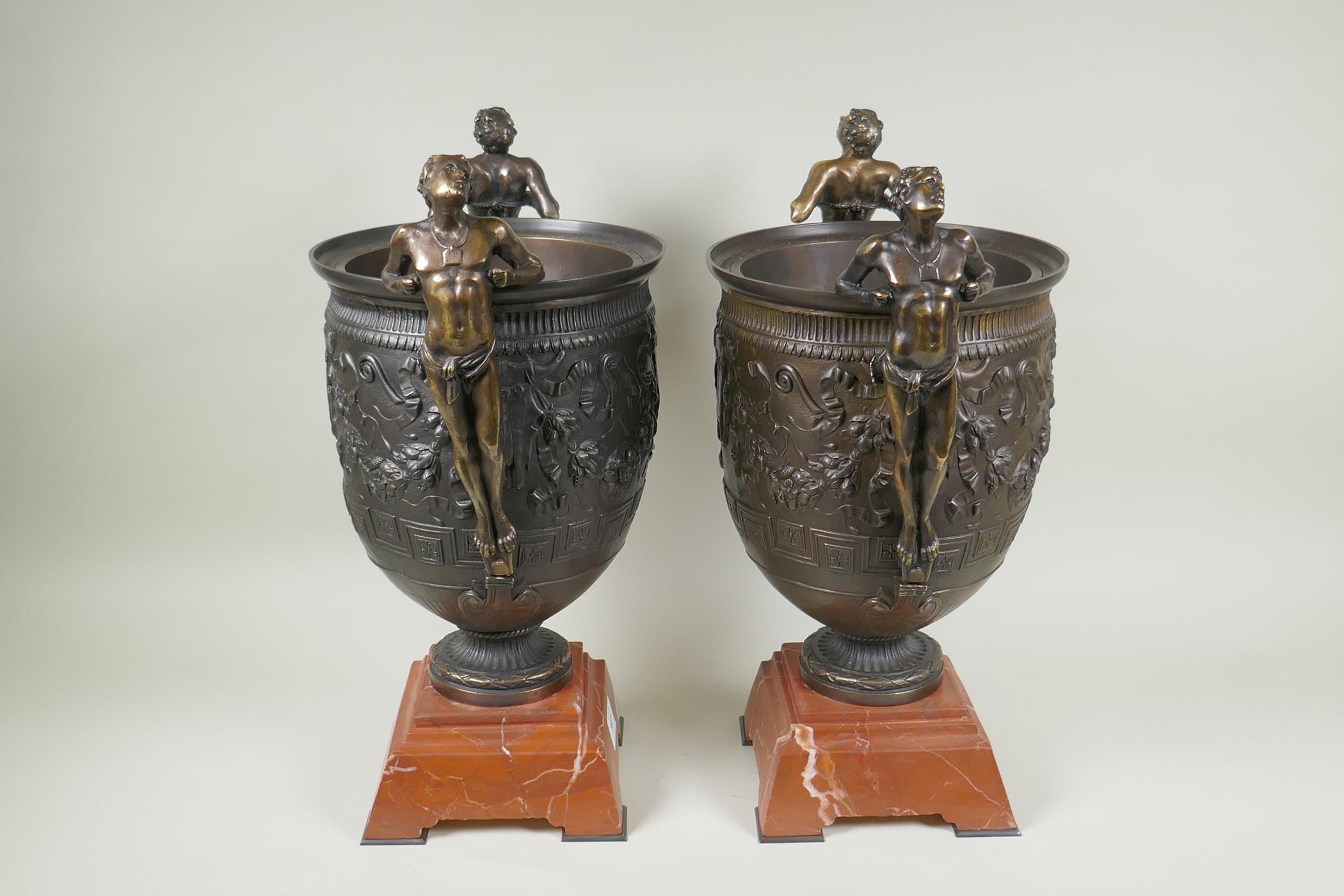 A pair of Grand Tour style bronze urns on red marbled bases, with male figural twin handles, 41cm - Image 4 of 6