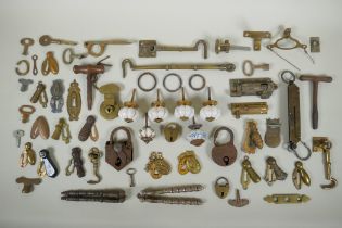 A collection of antique bronze and brass door furniture, porcelain drawer handles, locks and keys