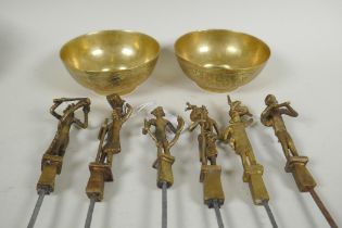 A set of six Indian gilt bronze figural skewers, 50cm long, and a pair of Islamic brass bowls
