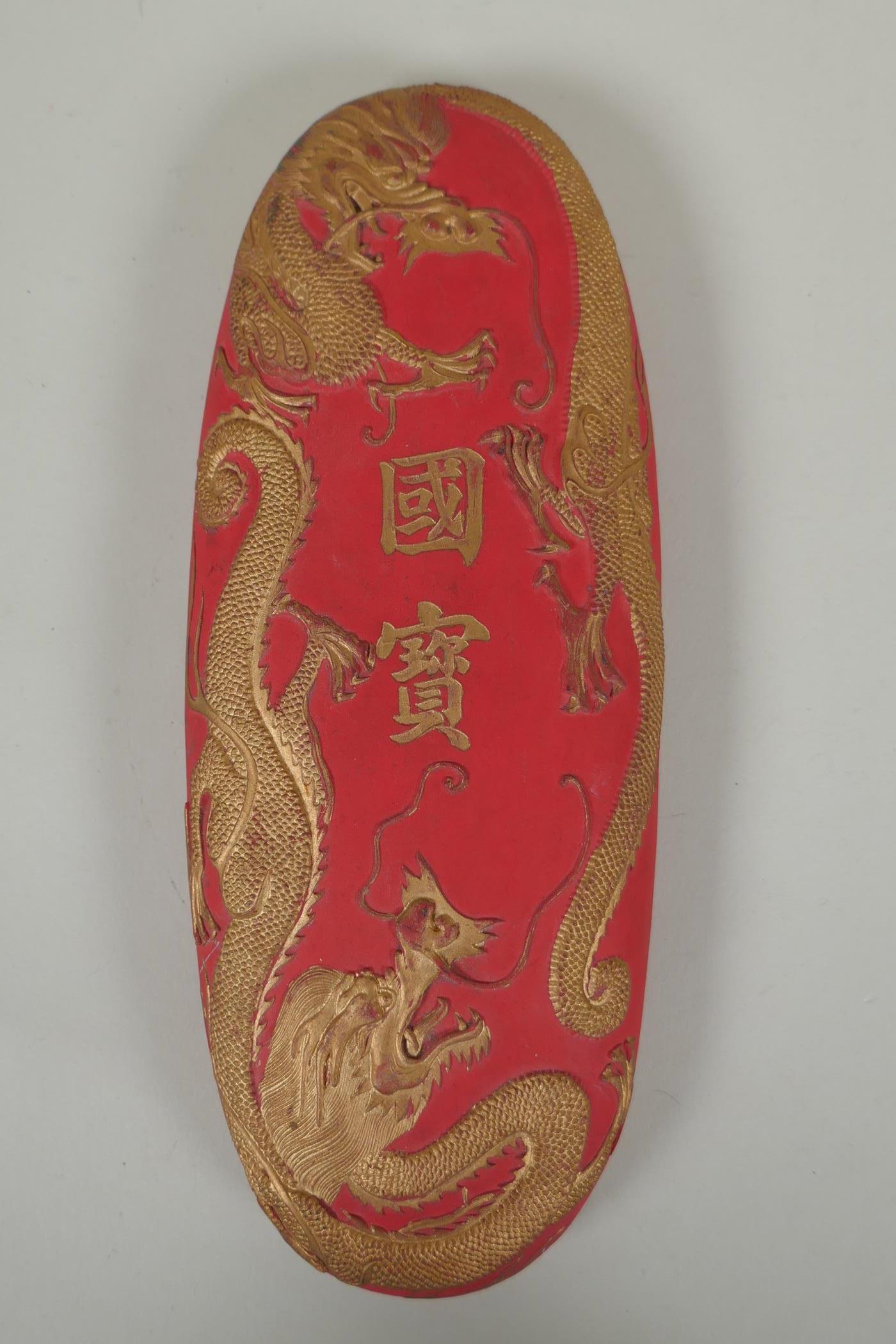 A Chinese red and gilt ink stone/block with raised dragon and character inscription decoration, 10 x