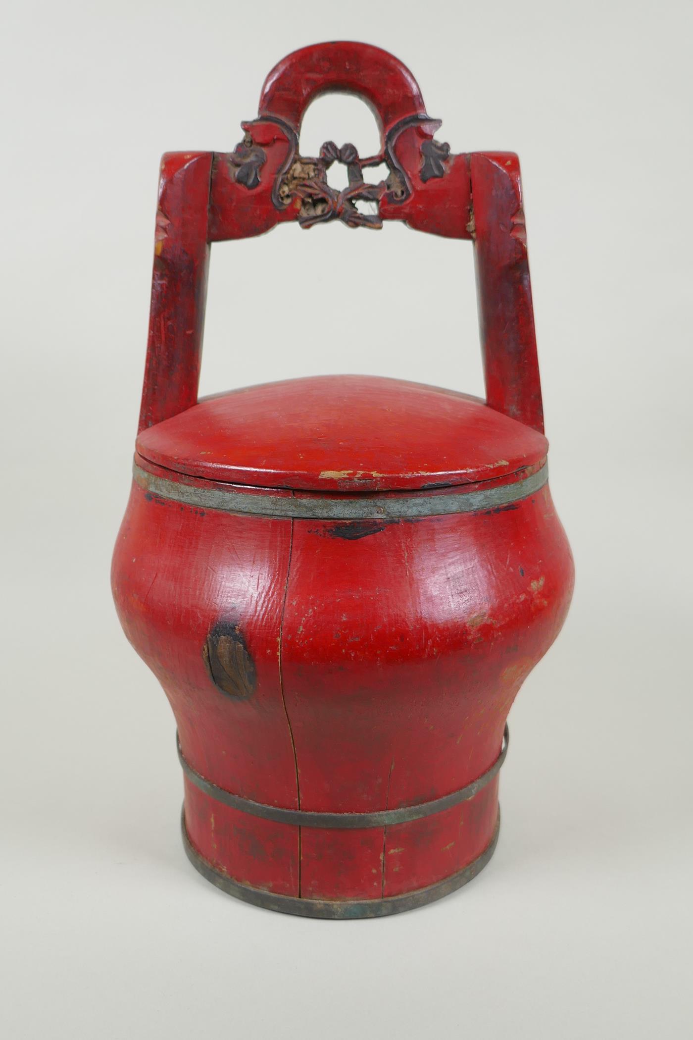 A Chinese red lacquered wood food carrier, 36cm high