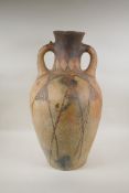 An antique North African terracotta amphora with two handles and hand painted design, AF, 63cm high