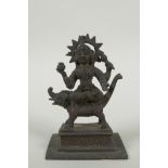 An antique Indian bronze figure of Durga riding a mythical creature, 12cm high