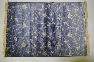 A blue ground Kashmir rug with gold scrolling floral design, 170 x 100cm
