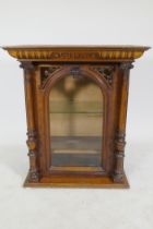 A walnut polyphon case, with pierced spandrels and arched glazed door with apple columns, 62 x 36