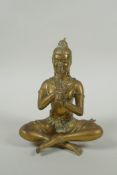 A Cambodian bronze figure of a seated musician playing a flute, 15cm high