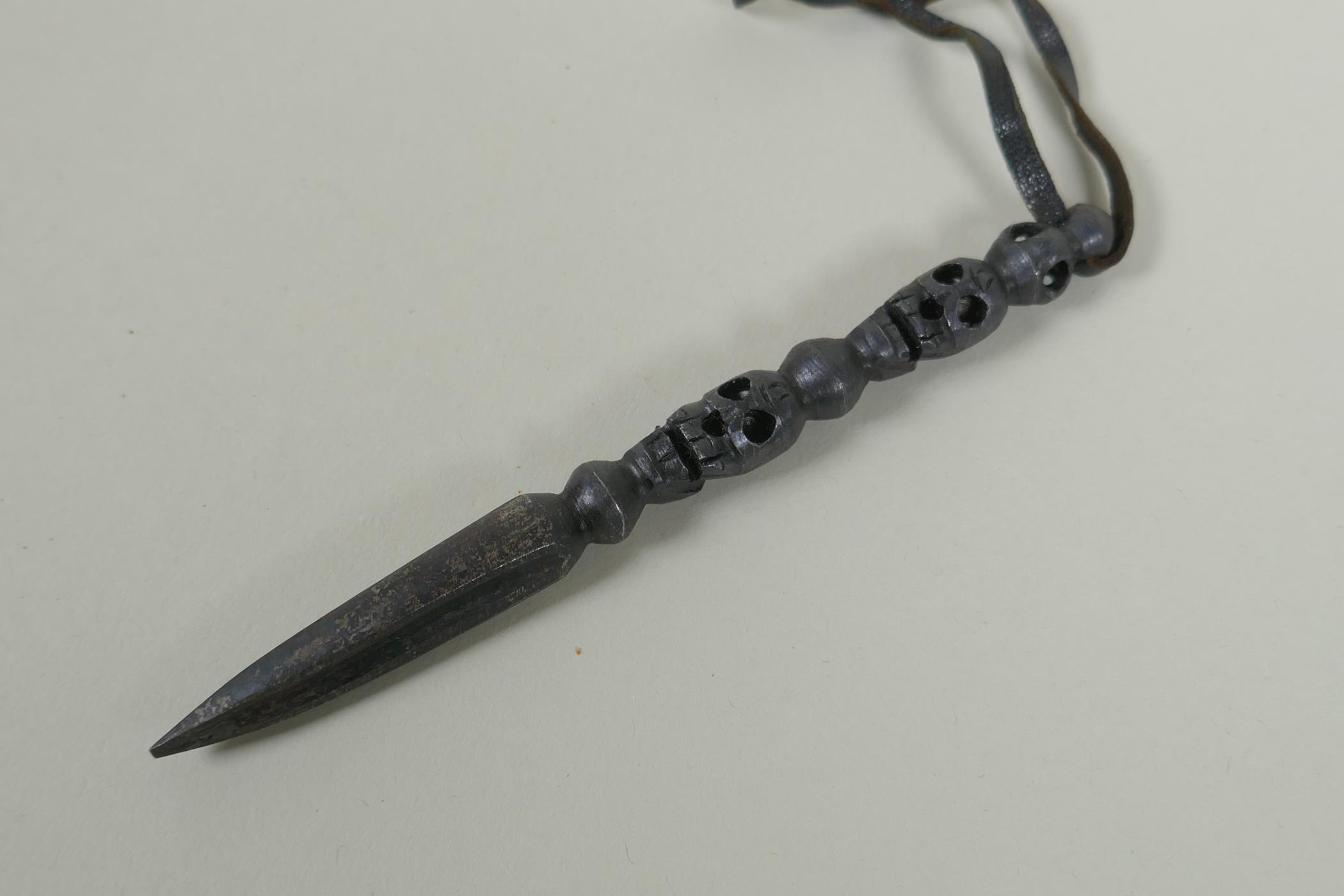 A Tibetan steel phurba with skull mask decorated to the handle and a miniature bronze vajra, 14cm - Image 3 of 3