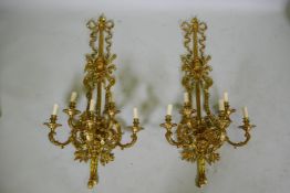 A pair of ormolu five branch sconces decorated with swags, masks and torches etc 119cm