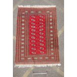 A red ground Bokhara rug with brown and orange borders, 128 x 175cm