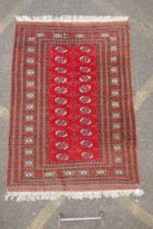 A red ground Bokhara rug with brown and orange borders, 128 x 175cm