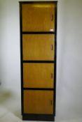 A bespoke mid-century cherry wood and black lacquer media cabinet of four cupboards, 56 x 49 x 193cm
